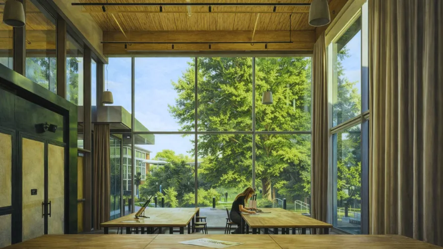A painted reading room, a student working by tall windows